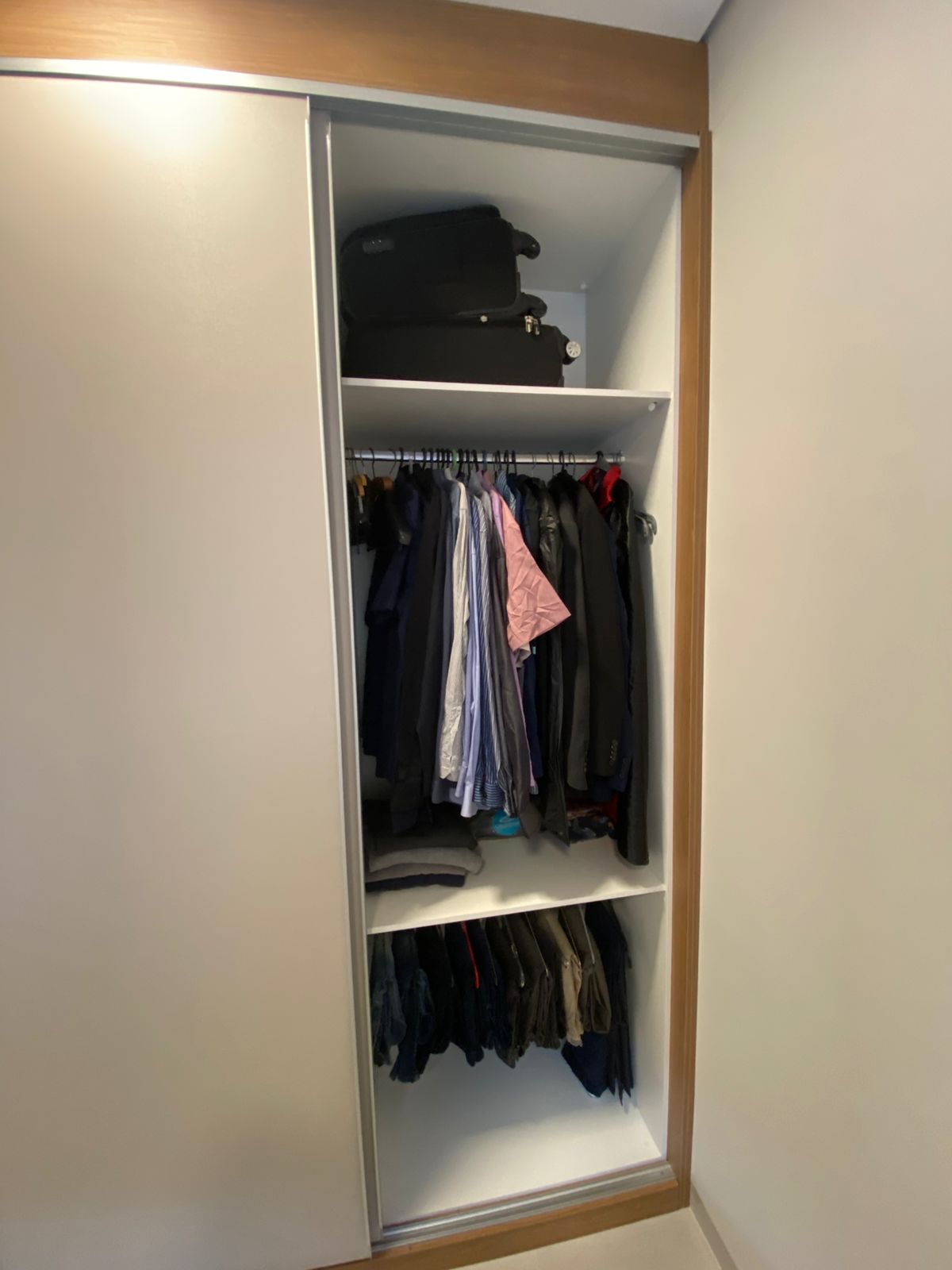 Guarda-roupa planejado de canto com portas de correr e acabamento em madeira