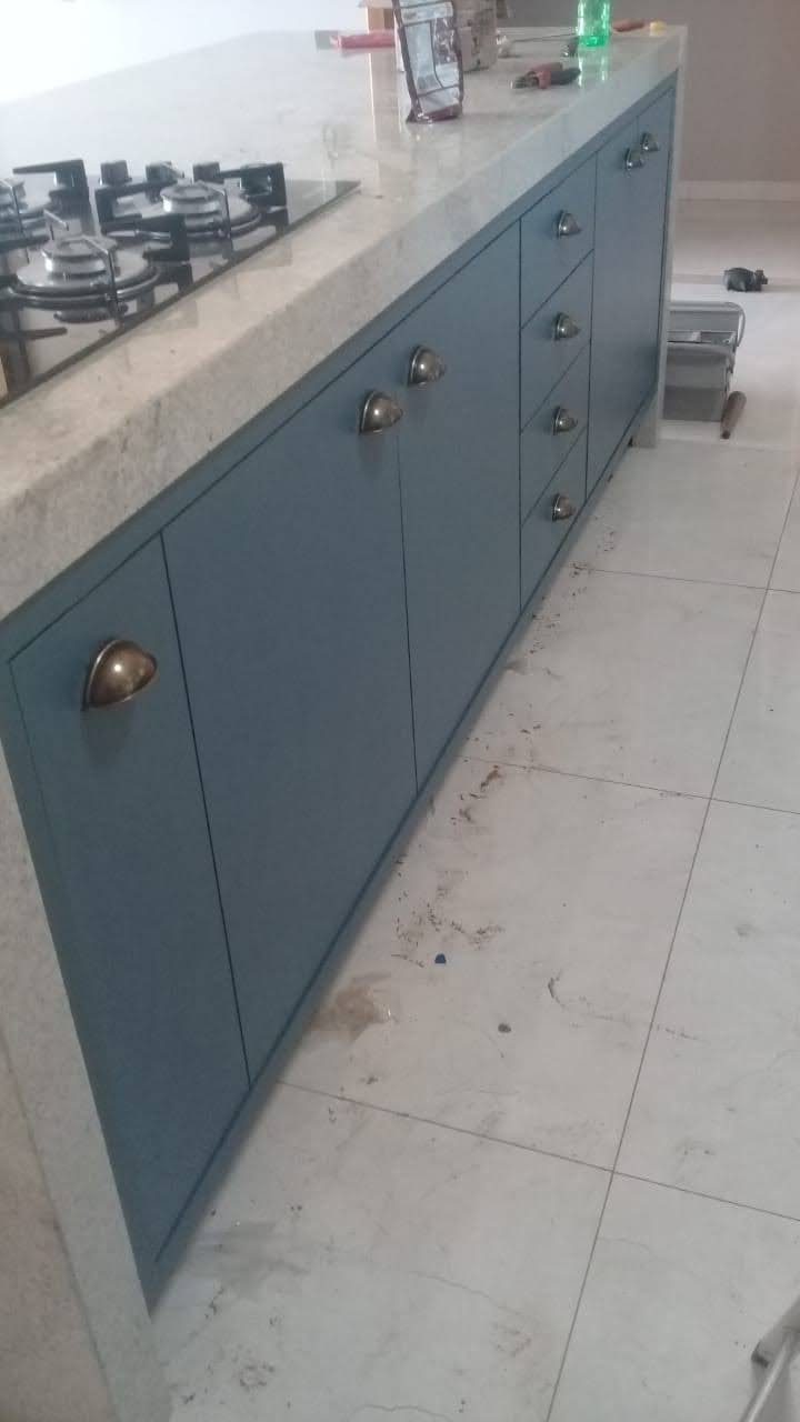 Lateral da ilha azul com portas, gavetas e acabamento da marcenaria planejada